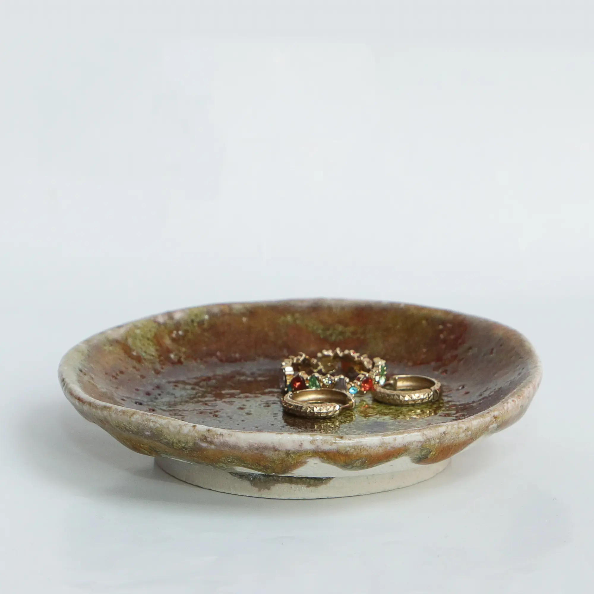 Nahaufnahme Kleine dunkelrote Schmuck Schale Deko Kunst Keramik Steinzeug neon grün rund