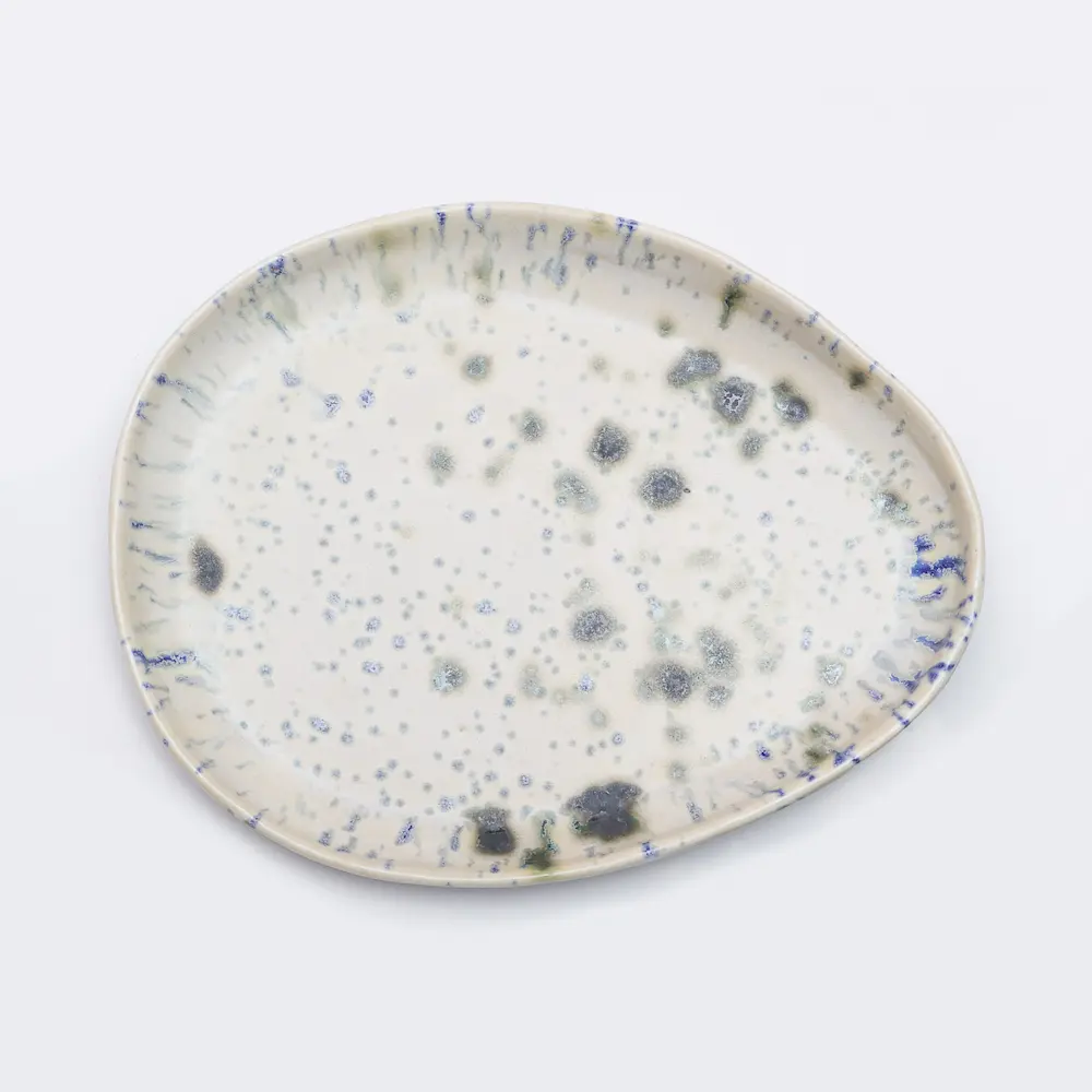 Nahaufnahme Große flache ovale Deko Schale Obst Weichporzellan Kunst Punkte Glasur creme